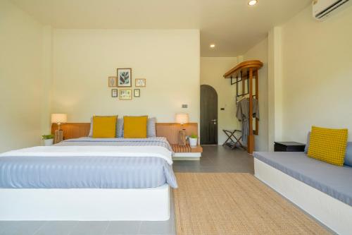 a bedroom with two beds with yellow and blue pillows at Sirin Farm Chiang Rai in Ban San Ton Ko (1)
