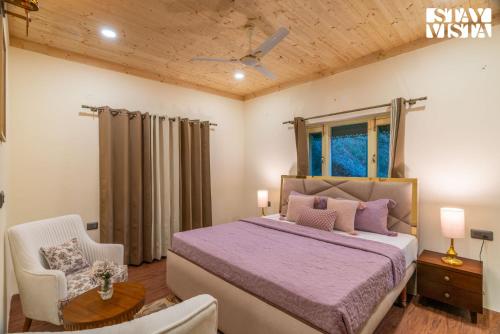 a bedroom with a large bed and a chair at StayVista at Cloudview Villa with WiFi and BBQ in Mussoorie