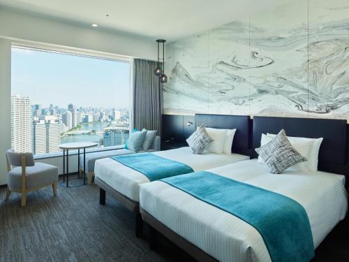 two beds in a hotel room with a large window at Mitsui Garden Hotel Toyosu Premier - Tokyo in Tokyo