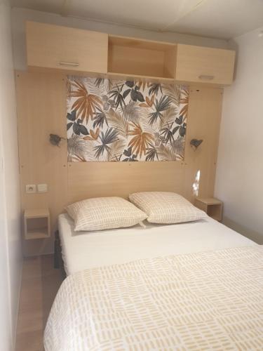 - une chambre avec un lit et un mur orné de fleurs dans l'établissement Mobil home 4 personnes avec clim, à La Roque-dʼAnthéron