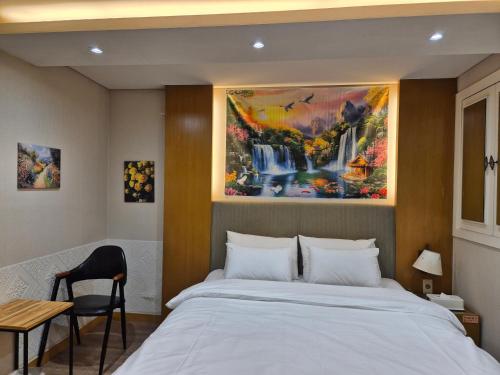 a bedroom with a bed and a painting on the wall at New Day Hotel Gangnam in Seoul