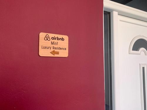 a sign on a red wall next to a door at Mint Luxury Residence in Spáta