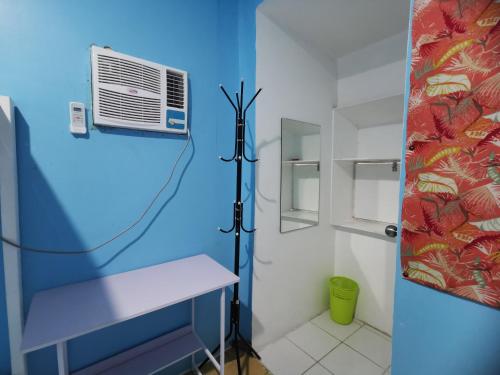 a bathroom with a blue wall and a air conditioner at Resort's Side Hostel near Shangrila in Cogon