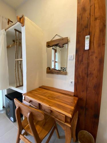 a wooden dressing table in a room with a mirror at Cozy bliss homestay sidemen in Sidemen