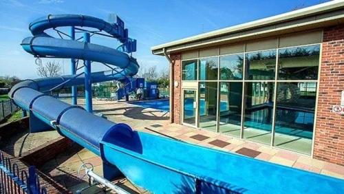 a blue water slide in front of a building at Mimosa holiday home in Little Clacton