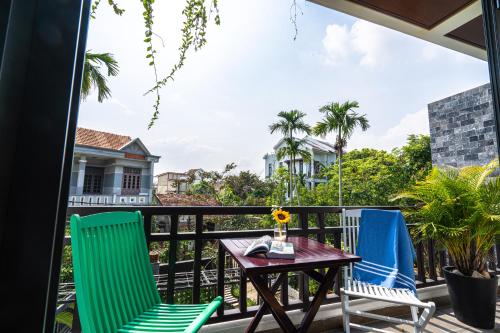 a patio with two chairs and a table on a balcony at Golden Star Villa Hoi An in Hoi An