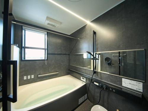 a bathroom with a tub and a shower and a toilet at Blue Ocean Awaji in Sumoto