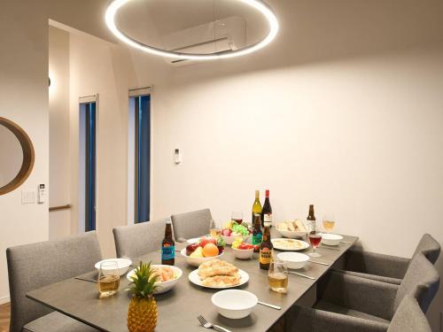 a dining room table with food and bottles of wine at Blue Ocean Awaji in Sumoto