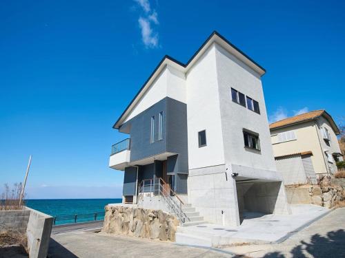 a white house with the ocean in the background at Blue Ocean Awaji in Sumoto