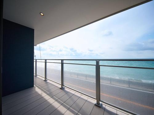 a balcony with a view of the beach and the ocean at Blue Ocean Awaji in Sumoto