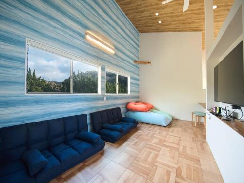 a living room with a blue couch and a large window at Blue Ocean Awaji in Sumoto