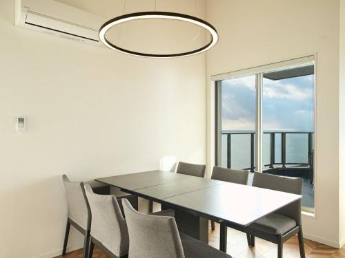 a dining room with a table and chairs and a window at Blue Ocean Awaji in Sumoto
