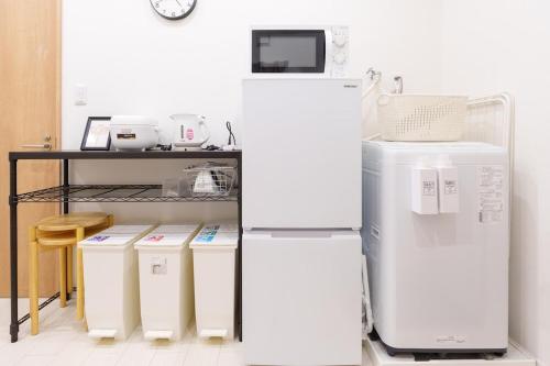 a kitchen with two white refrigerators and a table at 楓屋1F 120Ta in Tokyo
