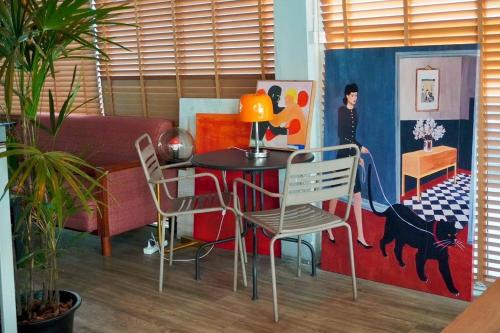 a living room with a table and chairs in a room at BW Thai Art Style Hotel in Bangkok