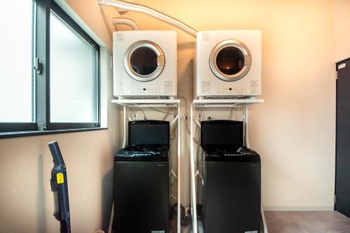 two microwaves and a washer and dryer in a room at LOCO Minamiichi in Nara