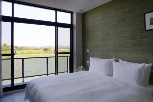 a bedroom with a large bed and a large window at Richen Shanshan in Chün-hsin