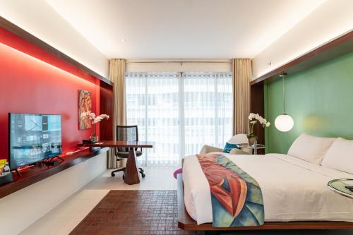 a bedroom with a large bed and a flat screen tv at The Picasso Boutique Serviced Residences Managed by HII in Manila