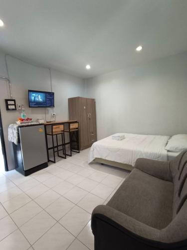 a room with a bed and a couch and a tv at Gift house in Hat Yai