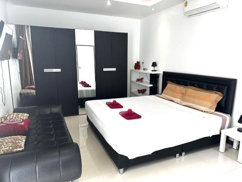 a bedroom with a bed and a leather couch at VILLA CHELONI 2 BEDROOMS in Kamala Beach