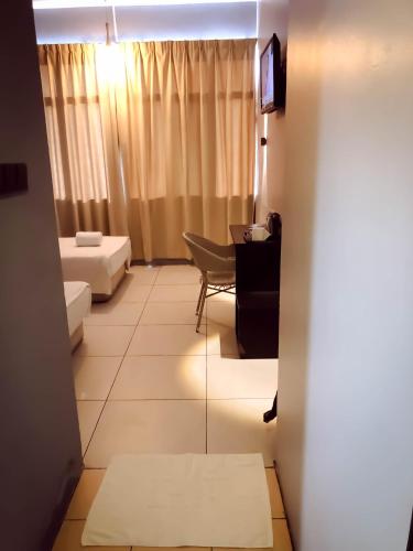 a living room with a couch and a table at De Choice Hotel Tawau in Tawau