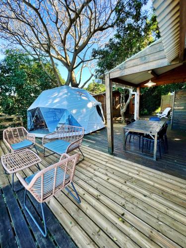 a patio with two chairs and a table and a tent at Bubble Dome Village in Saint-Joseph