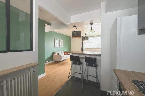 - une cuisine et un salon avec un bar et des tabourets dans l'établissement Colonel Rozanoff - Charm and comfort in the heart of the 12ᵉ arrondissement, à Paris