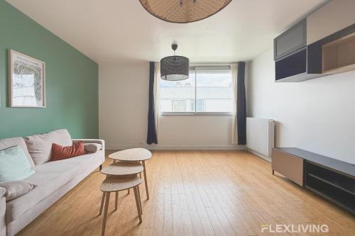 un salon avec un canapé et une table dans l'établissement Colonel Rozanoff - Charm and comfort in the heart of the 12ᵉ arrondissement, à Paris