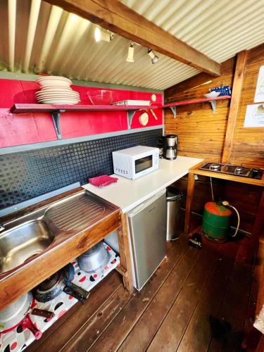 a small kitchen with a counter and a microwave at Bubble Dome Village in Saint-Joseph