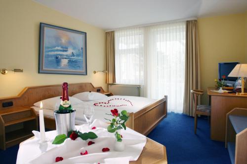a hotel room with a bed with flowers on a table at AKZENT Waldhotel Spa Rügen in Göhren
