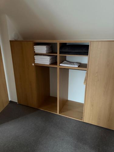a wooden cabinet with folded towels in a room at Apartmány Šestka in Staré Město