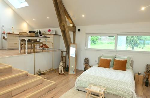 Cet appartement comprend une chambre avec un lit, une cuisine et des escaliers. dans l'établissement Le photo studio, à Tremblois-lès-Rocroi