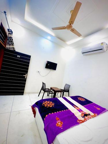a bedroom with a bed and a table and a ceiling fan at Mahima hotel in Samālkha