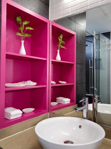a bathroom with a pink cabinet with a sink at ÊMM Hotel Saigon in Ho Chi Minh City