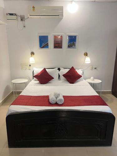 a bedroom with a large bed with red pillows at Peaceful studio home in South Goa in Salcete