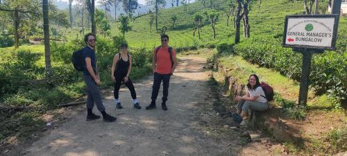 a group of people standing on a dirt road next to a sign at Rohana Estate Lodging & Camping in Kandy