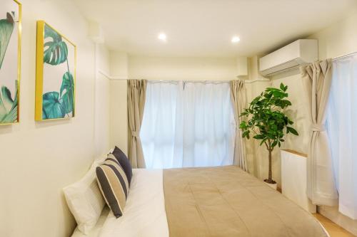 una camera da letto con un letto e una finestra con una pianta di 120Tb 楓屋2F 楓屋アネックス 67m貸切 三田線志村坂上駅徒歩10分東京タワー直通キッズスペースリノベ a Tokyo