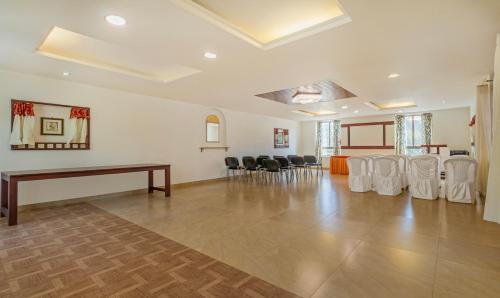 a large room with a table and chairs in it at Treebo Sadhoo Heritage in Kannur