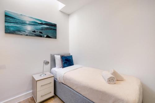 a bedroom with two beds and a nightstand and a painting at Luxury 5 Bedroom, 4 Bathroom Home in Purley in Purley