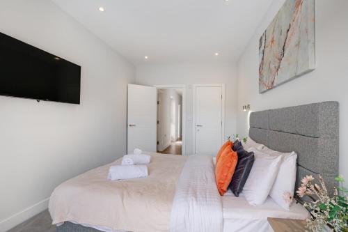 a bedroom with a large bed and a flat screen tv at Luxury 5 Bedroom, 4 Bathroom Home in Purley in Purley