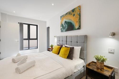a bedroom with a large bed with yellow pillows at Luxury 5 Bedroom, 4 Bathroom Home in Purley in Purley