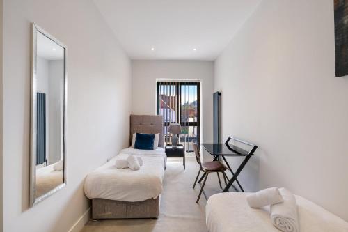 a room with two beds and a mirror and a desk at Luxury 5 Bedroom, 4 Bathroom Home in Purley in Purley