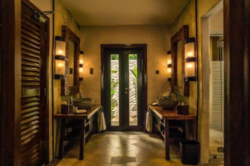 a hallway with two sinks in a room with a door at The Banjaran Hotsprings Retreat in Ipoh
