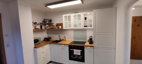 a kitchen with white cabinets and a stove top oven at Villa Hilda in Moosheim