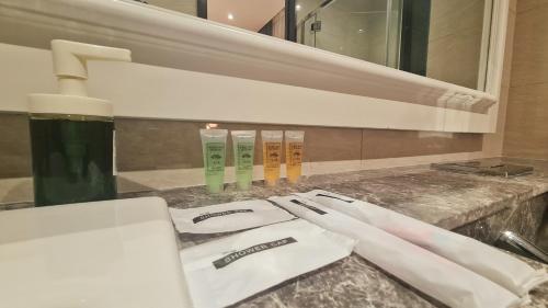 a bathroom counter with three toothbrushes and a sink at Harmony Luxury Suites At TM Persiaran Stonor KLCC in Kuala Lumpur