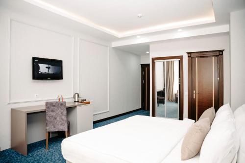 a hotel room with a bed and a desk at Grand Hotel Baku Central Park in Baku