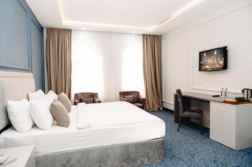 a hotel room with a bed and a desk at Grand Hotel Baku Central Park in Baku