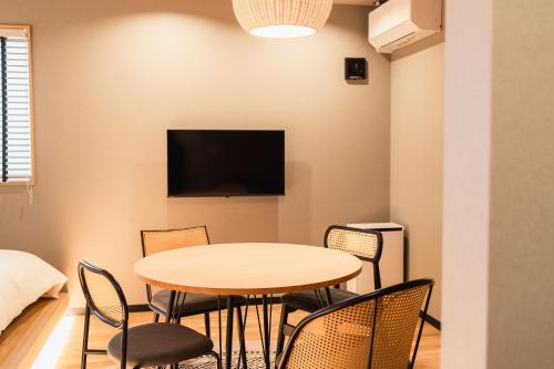 a table and chairs in a room with a tv at Beppu 乃音 in Beppu