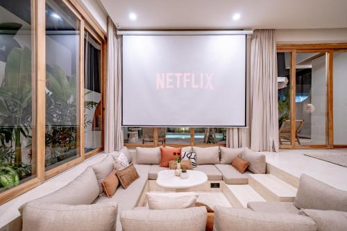 a living room with a couch and a large screen at Villa Samara Pererenan in Tumbak Bayuh
