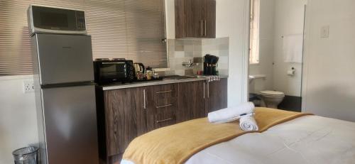 a kitchen with a refrigerator and a microwave at Carrington Guesthouse in Kimberley