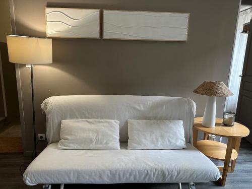 a white couch with two pillows next to a lamp at La Maison Vieille Maison d'Hôtes & Gîtes in Carcassonne